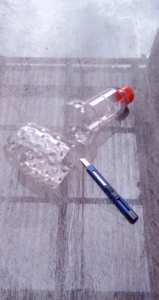 Eine leere Plastik-Flasche wurde mit einem Teppich-Messer in der Mitte auseinander geschnitten.