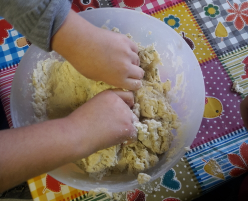 Ein Kind knetet Brot·teig. (Foto: Katharina Gebel)