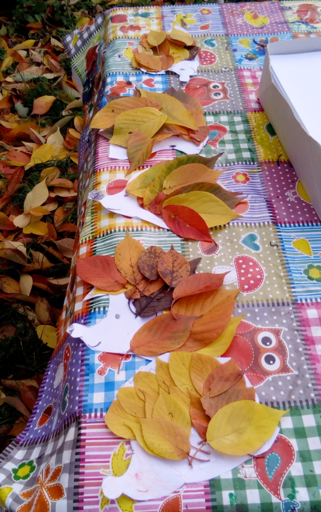 Foto vom Basteltisch. Darauf liegen 5 Laub-Igel, die aus Papier und Blättern geklebt wurden. (Foto: Katharina Gebel)