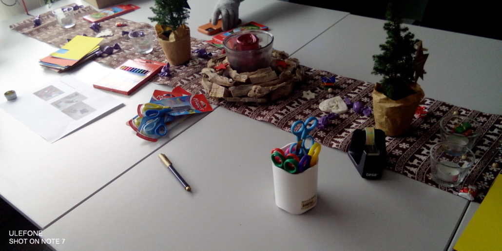 Foto des Bastel-Tischs im Haus. Darauf liegen Buntstifte, Scheren und Weihnachts-Dekoration. (Foto: Katharina Gebel)