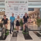 Das Foto zeigt vier Personen im Donaueinkaufszentrum vor dem großen Plakat von "Energie wird Natur". In der Mitte stehen zwei, links und rechts sind zwei Personen auf den Fahrrädern. (Foto: Stefanie Schmid)