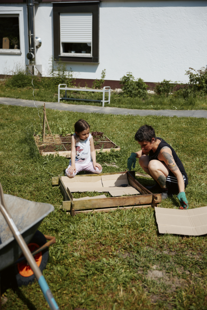 Das Foto zeigt ein Kind und die Projektleitung, die gerade ein neues Beet anlegen. (Foto: ©BJR/Johnke)