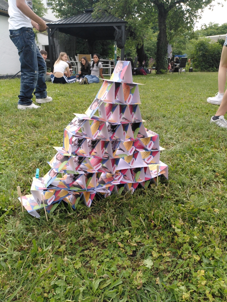 Das Foto zeigt einen anderen Turm mit Postkarten. Er ist aus Dreiecken aus Karten aufgebaut. (Foto: Barbara Kießling)