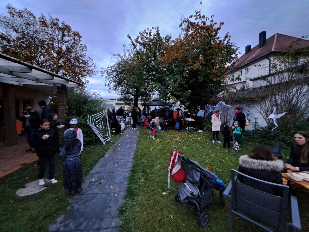 Das Foto ist eine größere Aufnahme von der Feier. Darauf sind viele Menschen im Garten verteilt. (Foto: Stadtjugendring Regensburg)